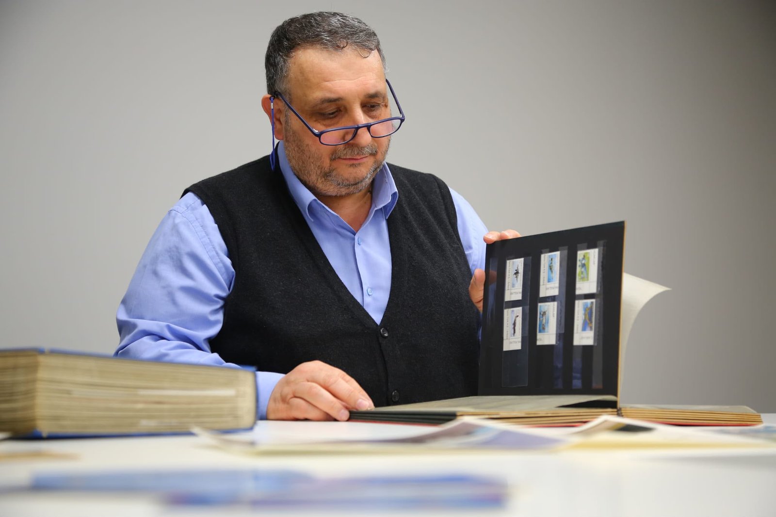 Orhan Özcanlı, koleksiyon albümünü incelerken
